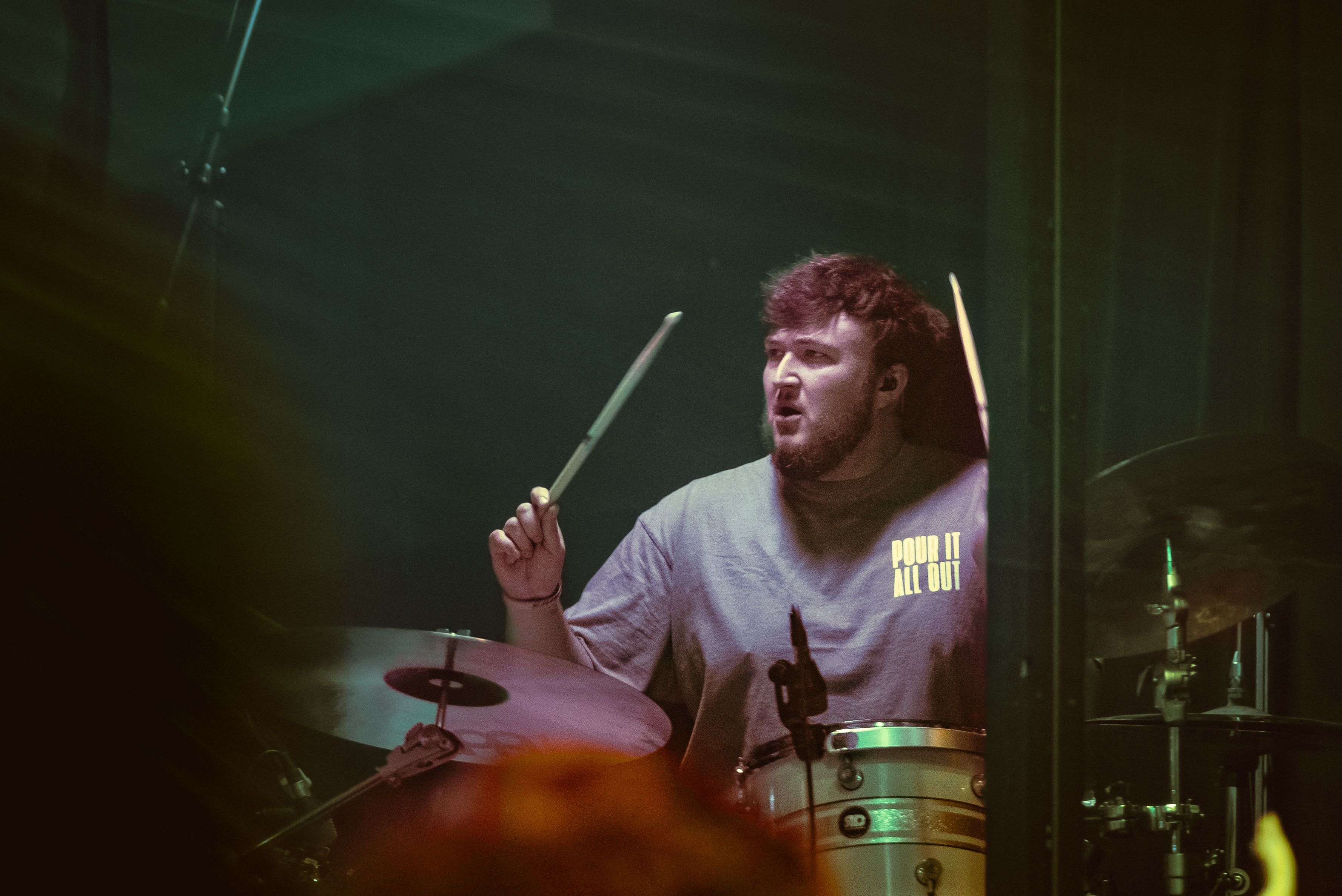A drummer mid-motion on a dark worship stage